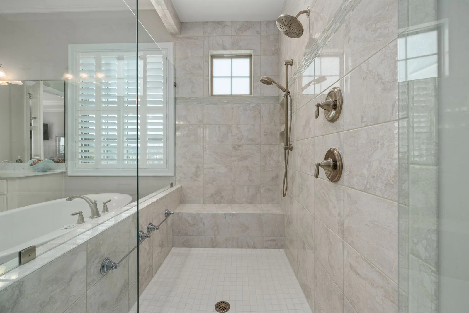 Modern bathroom interior showcasing a luxurious shower with white tiles and glass doors