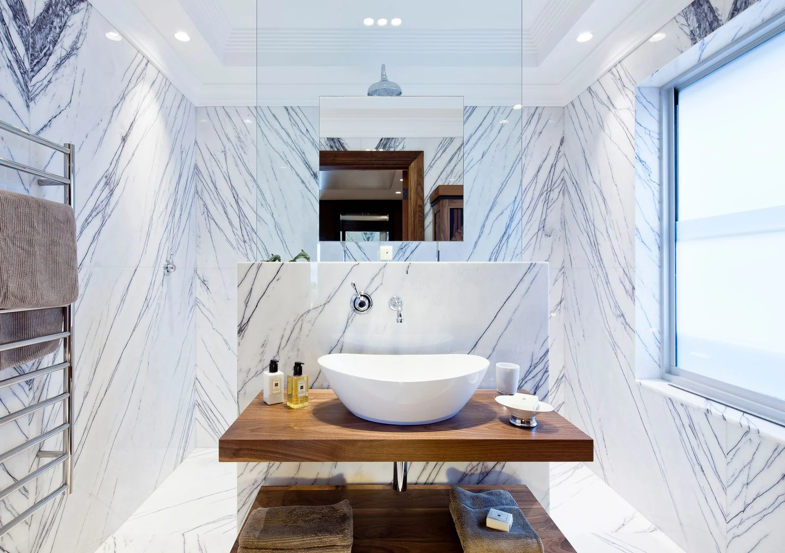 Contemporary bathroom design featuring marble walls and modern sink
