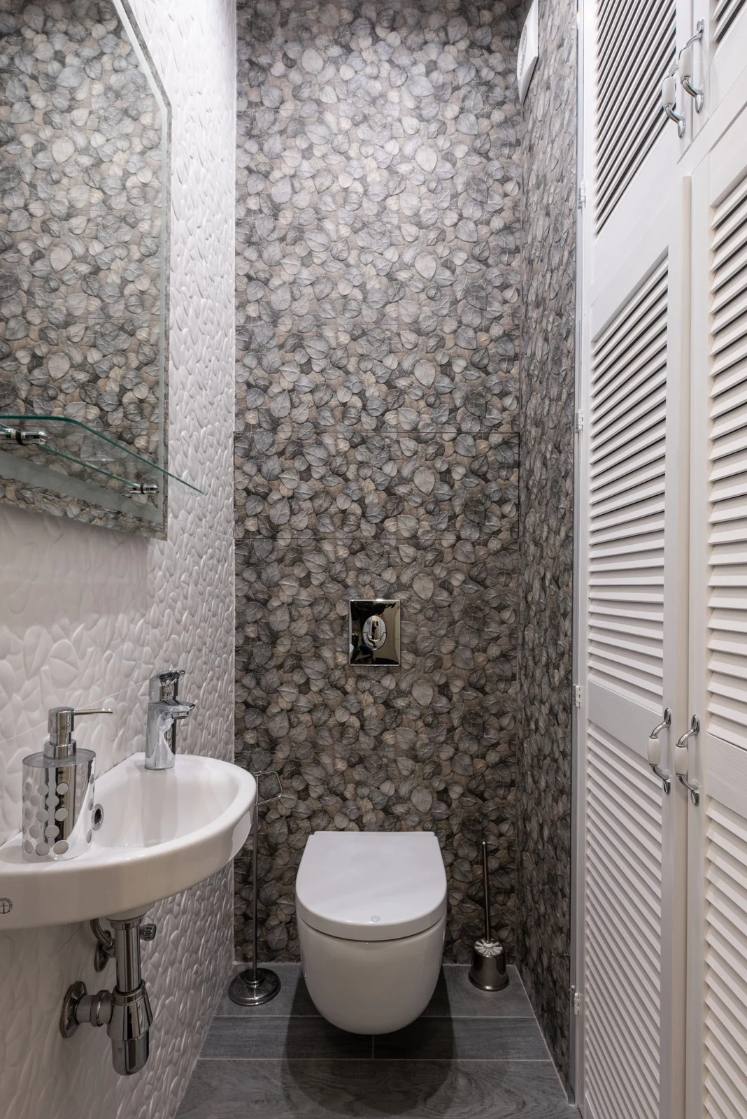 Stylish and compact bathroom featuring modern fixtures, elegant tiles, and a minimalist sink and toilet setup
