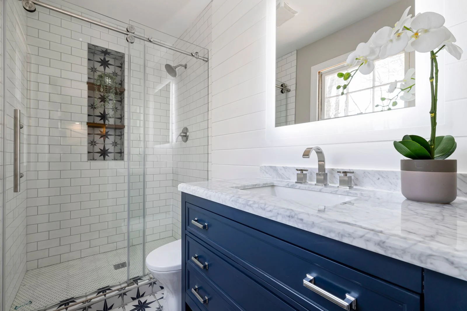 A stylish bathroom interior with marble countertop and glass shower