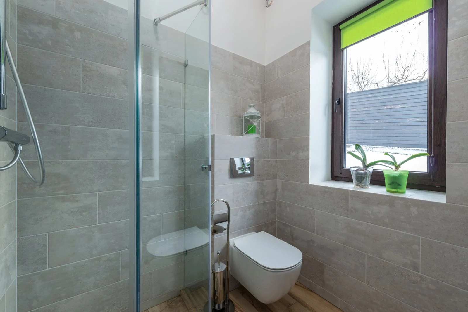 Contemporary bathroom featuring a glass shower, window, and minimalist design elements