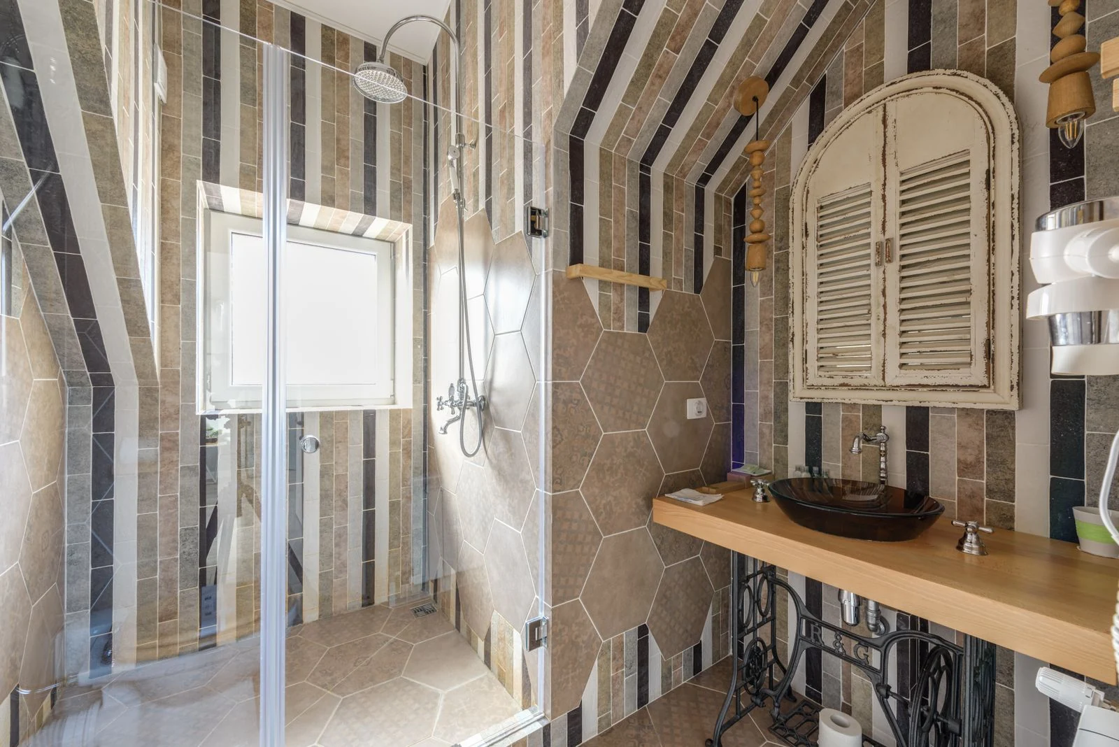 Beautifully designed bathroom featuring stylish tiles, glass shower, and unique sink area